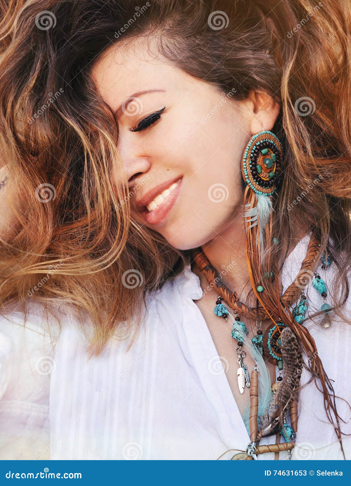 beauty close up fashion smiling woman portrait with handmade necklace and earrings made with beads, leather and feathers, boho chi