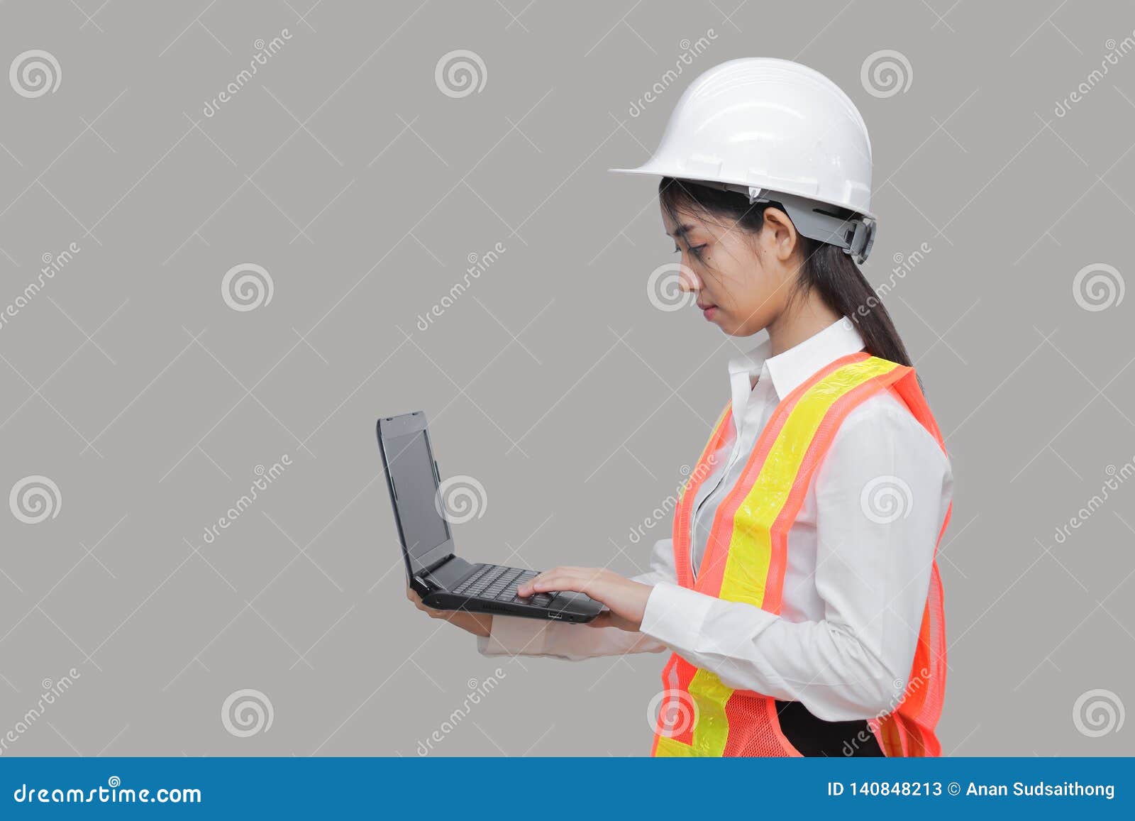 beauty confident young asian worker with safty equipment carrying laptop on gray  background