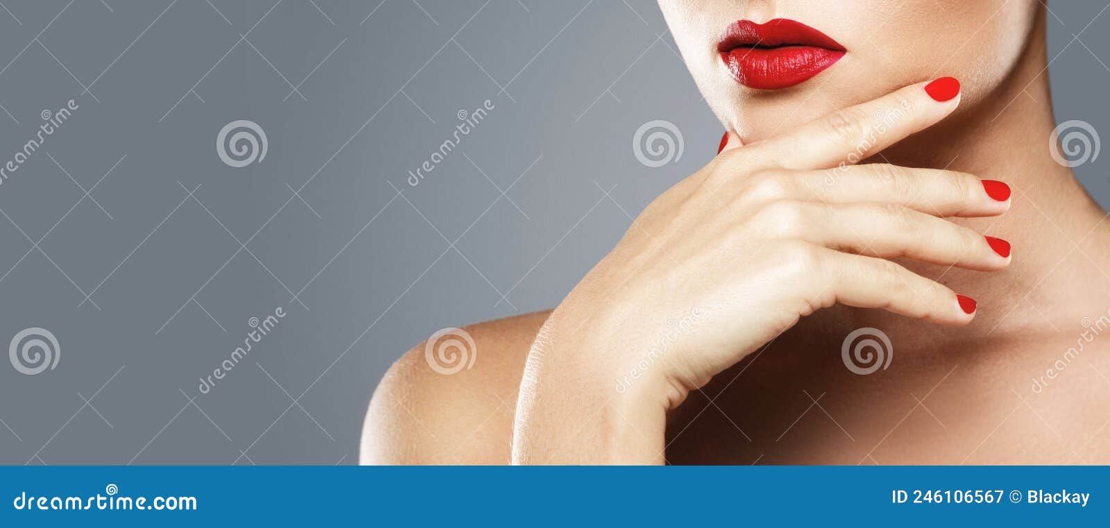 close-up of female mouth and nails with red manicure and lipstick.