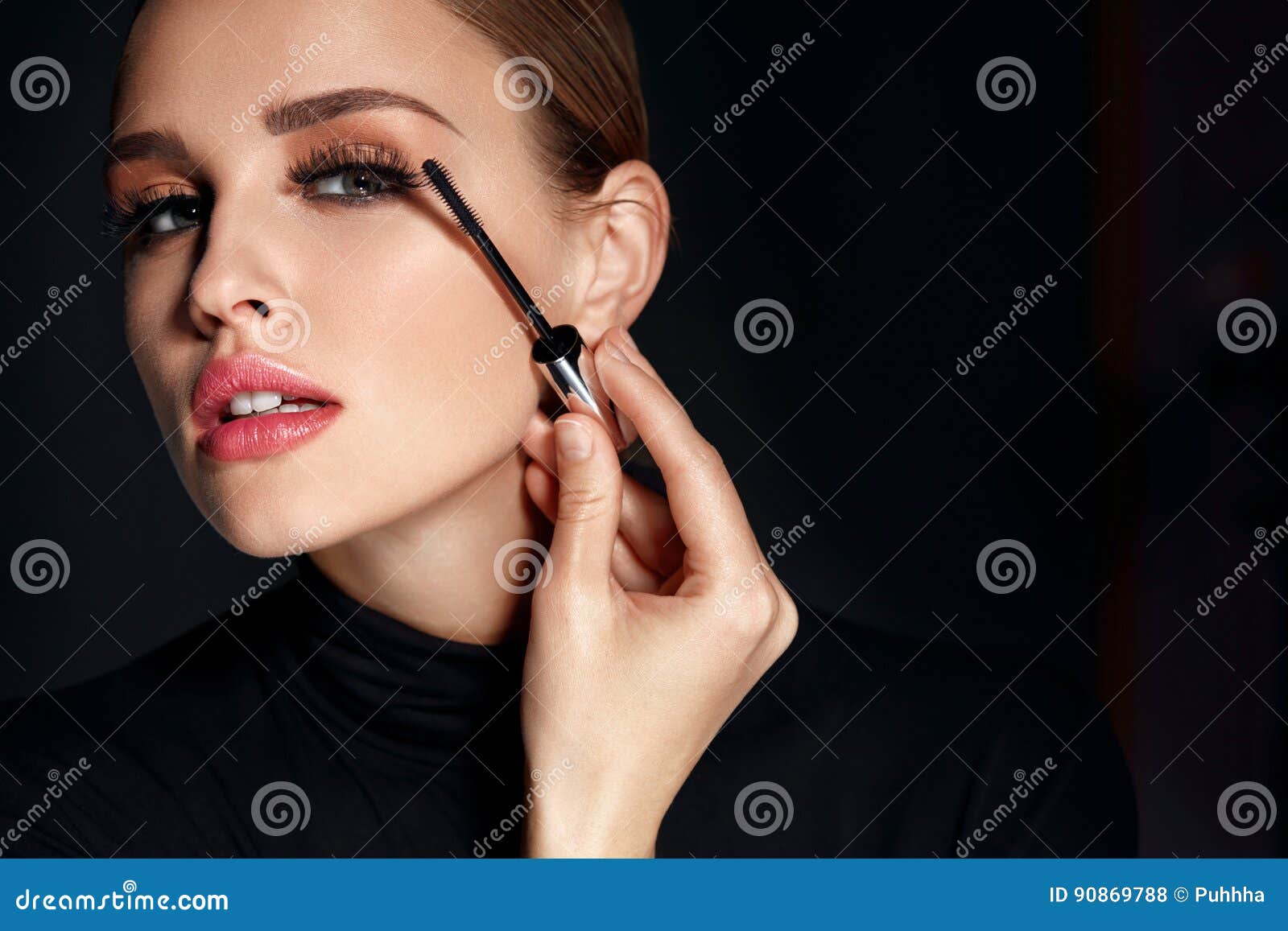 beauty cosmetics. woman putting black mascara on long eyelashes