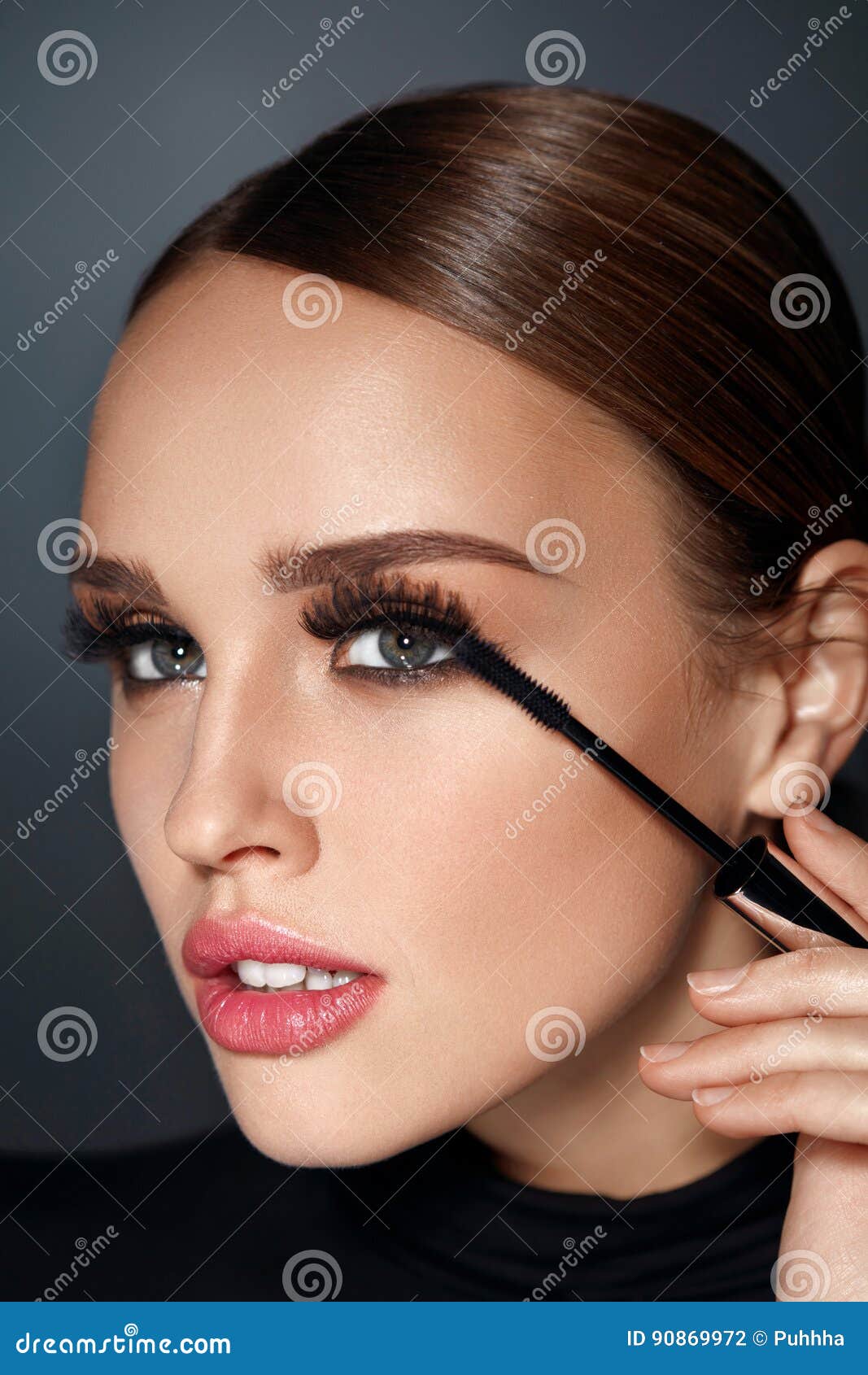 beauty cosmetics. woman putting black mascara on long eyelashes