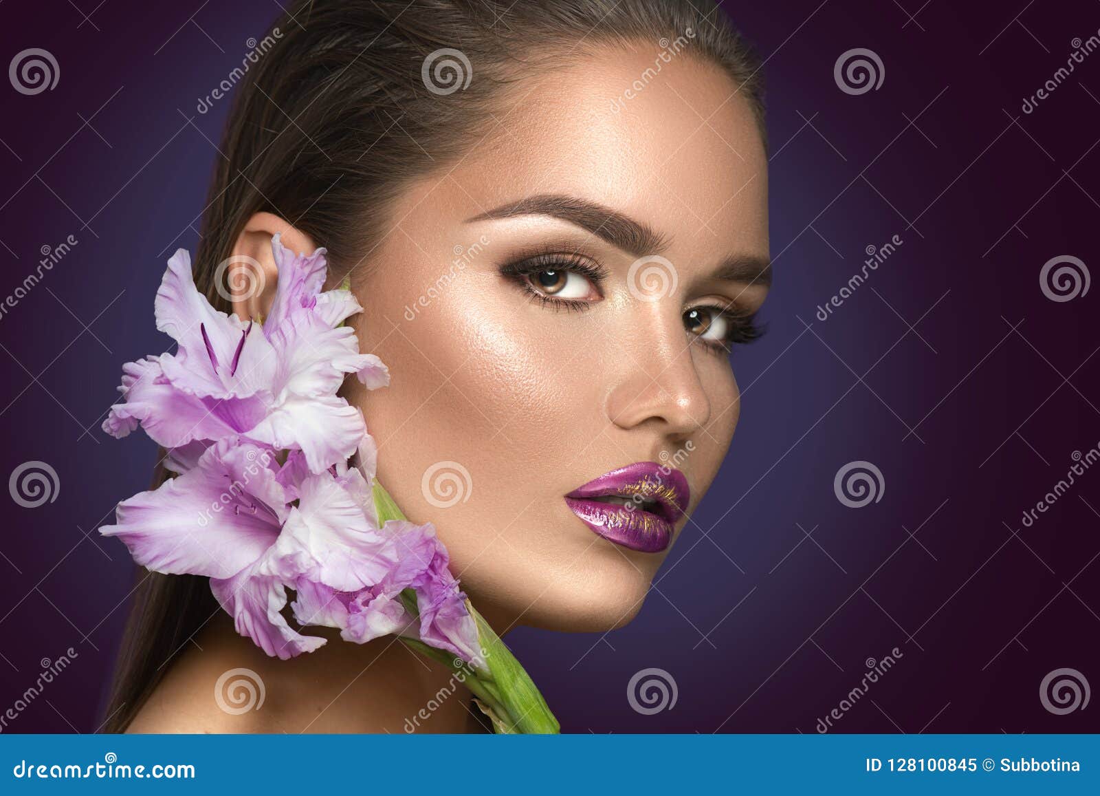 beauty fashion brunette girl with gladiolus flowers. glamour woman with perfect violet trendy makeup