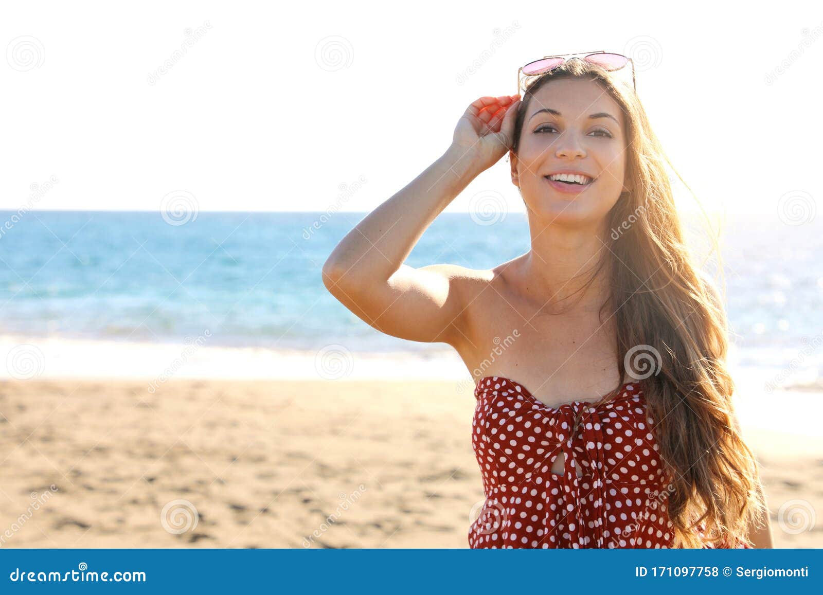Beauty Fashion Tanned Woman With Sunglasses On Her Head On The Beach Looking To The Camera Stock