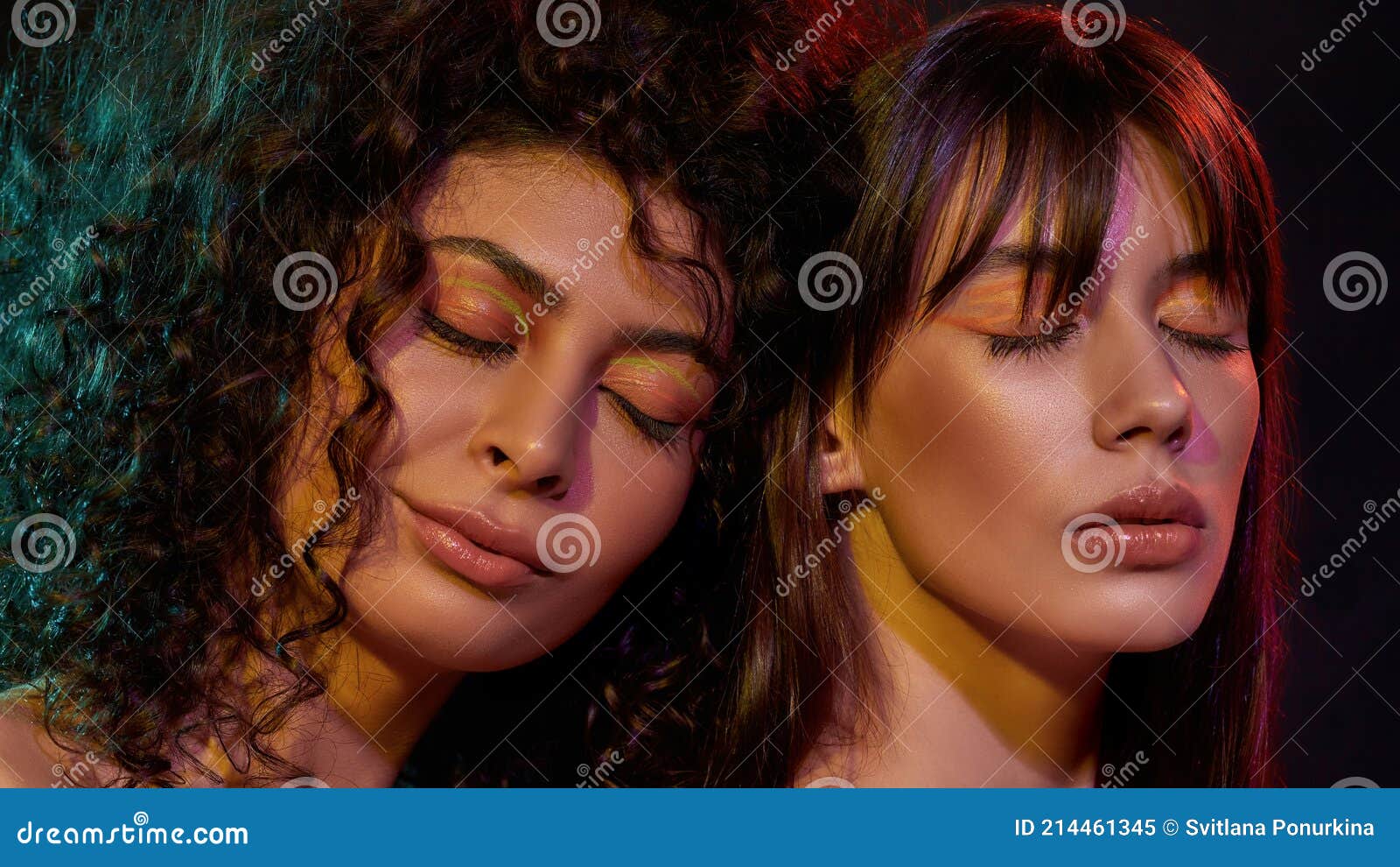 beauty portrait of two young brunette female models with professional art makeup posing with eyes closed in neon light