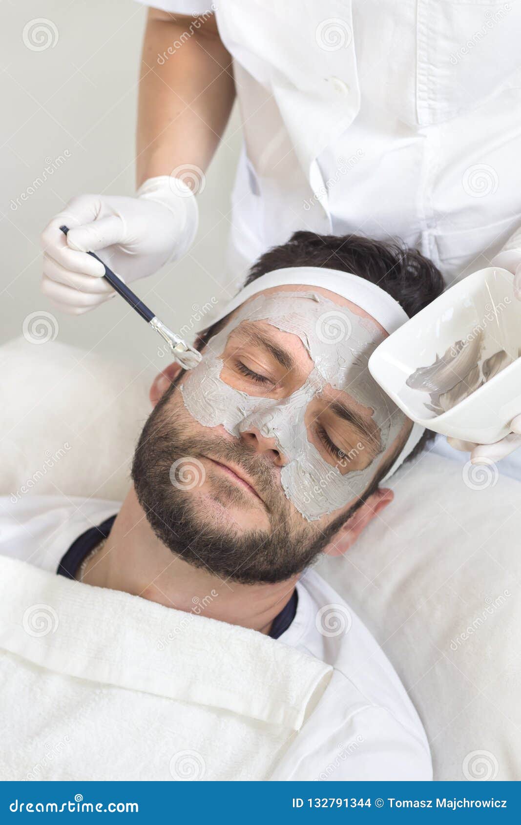 Beauty Salon the Beautician Puts a Mask on the Man`s Face with a Brush Beauty Salon the Beautician Puts a Mask on the Man`s Face with a Brush