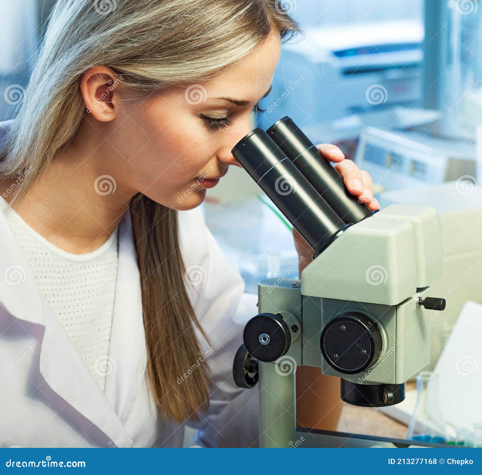 Beauty Scientist Looks in Microscope in Chemical Laboratory Stock Photo