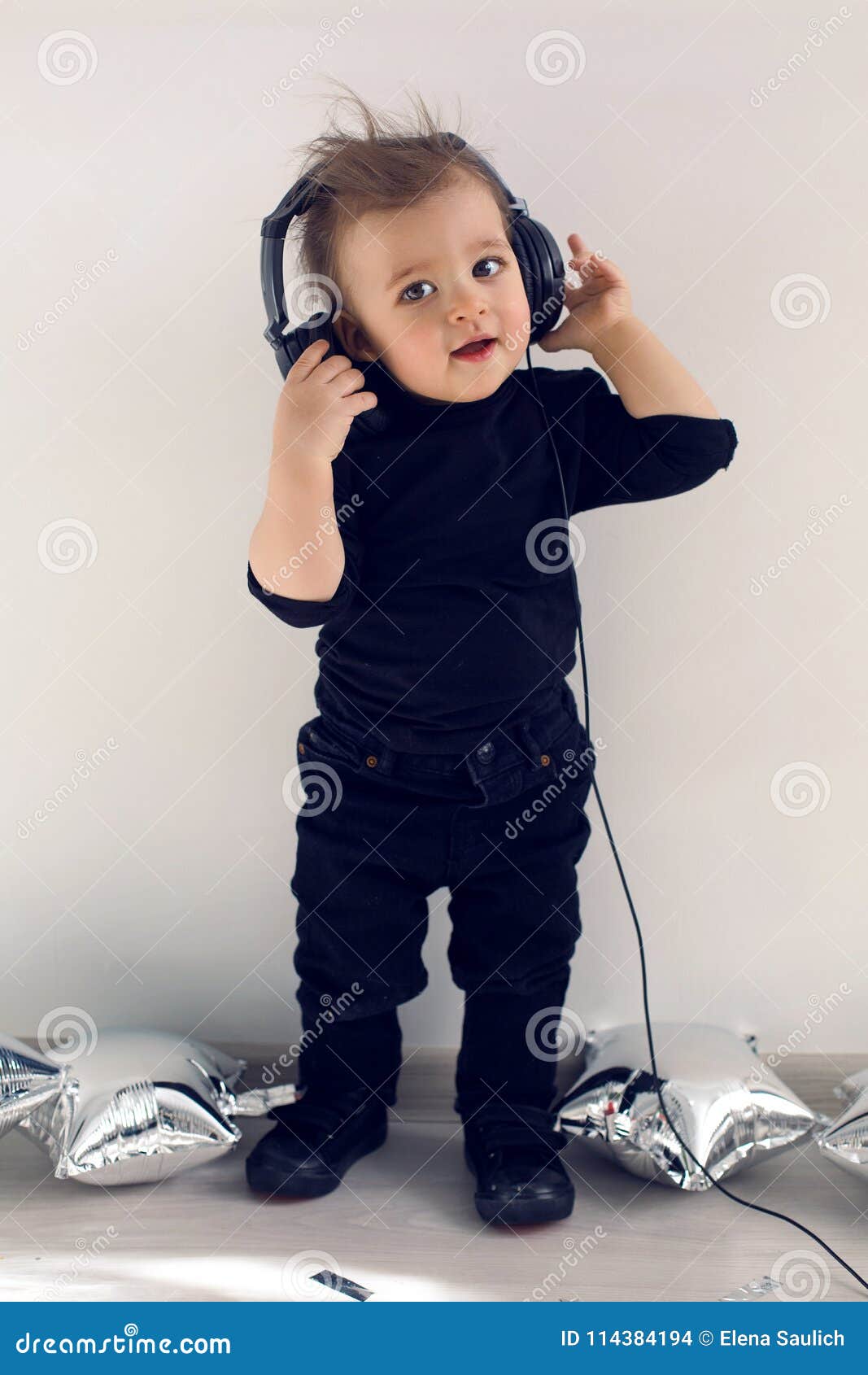 Bebé Un Año En Ropa Negra Que Escucha La Música Rock Foto de archivo - Imagen de 114384194