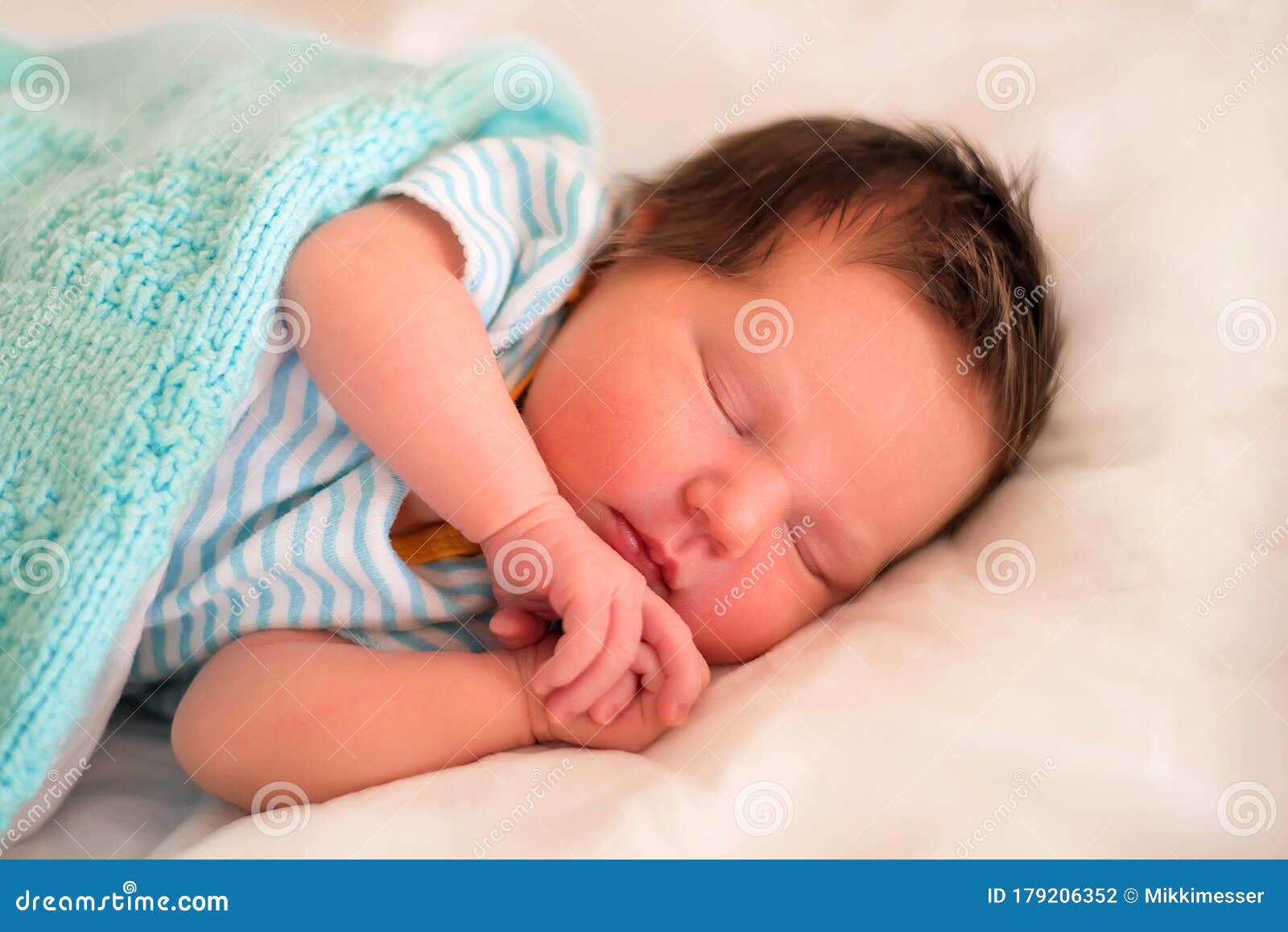 Bebé recién nacido niño en cama. Niño recién nacido duerme bajo