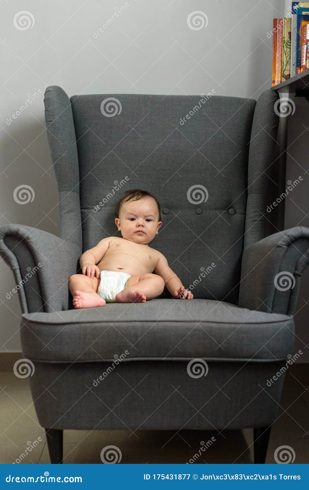 Bebé sentado en un sillón imagen de archivo. Imagen de feliz - 175431877