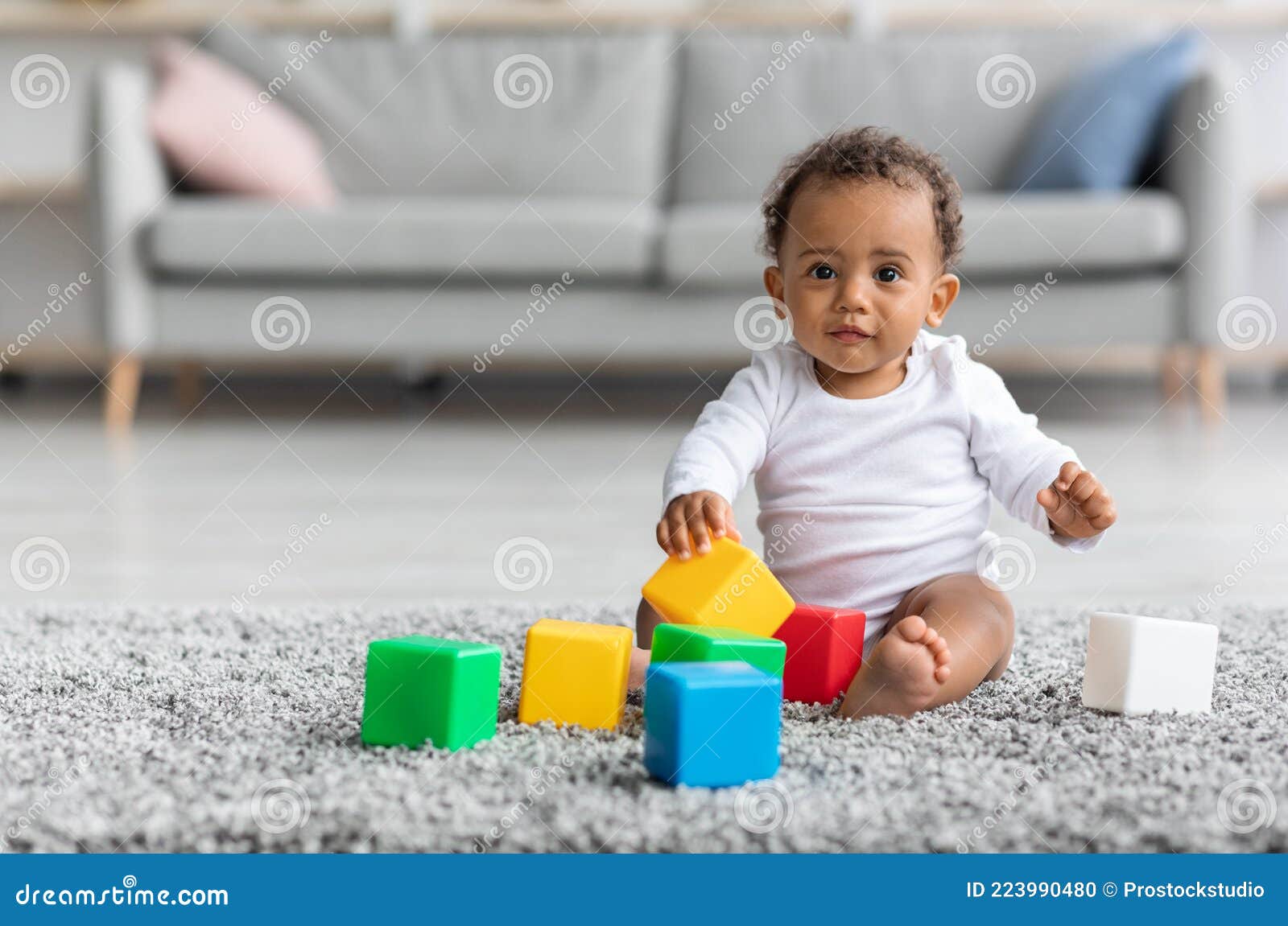 Mãe brincando com o jogo de pirâmide de bebê de 1 ano sentado em casa