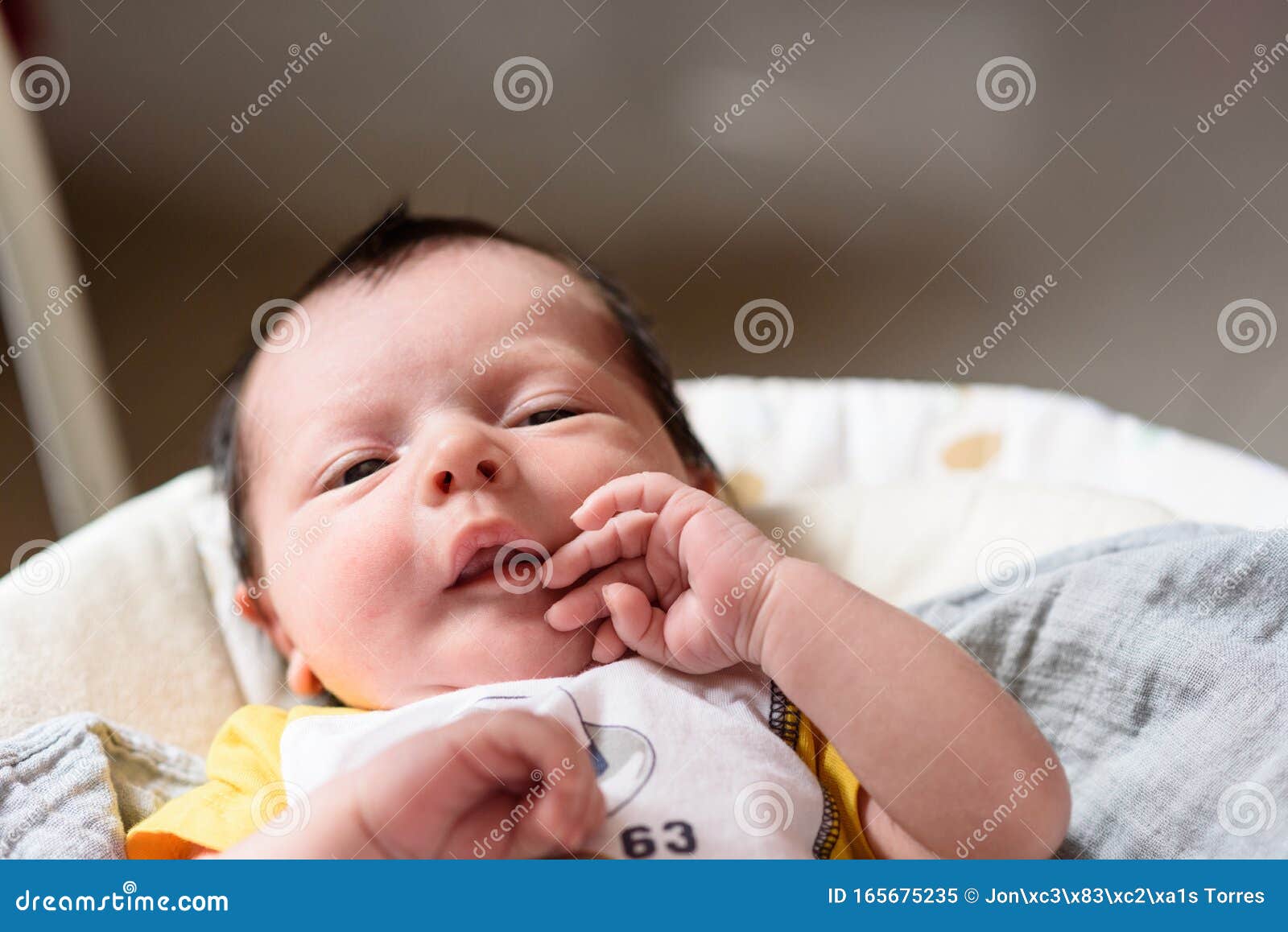 bebe with yellow and white body lying on baby hammock