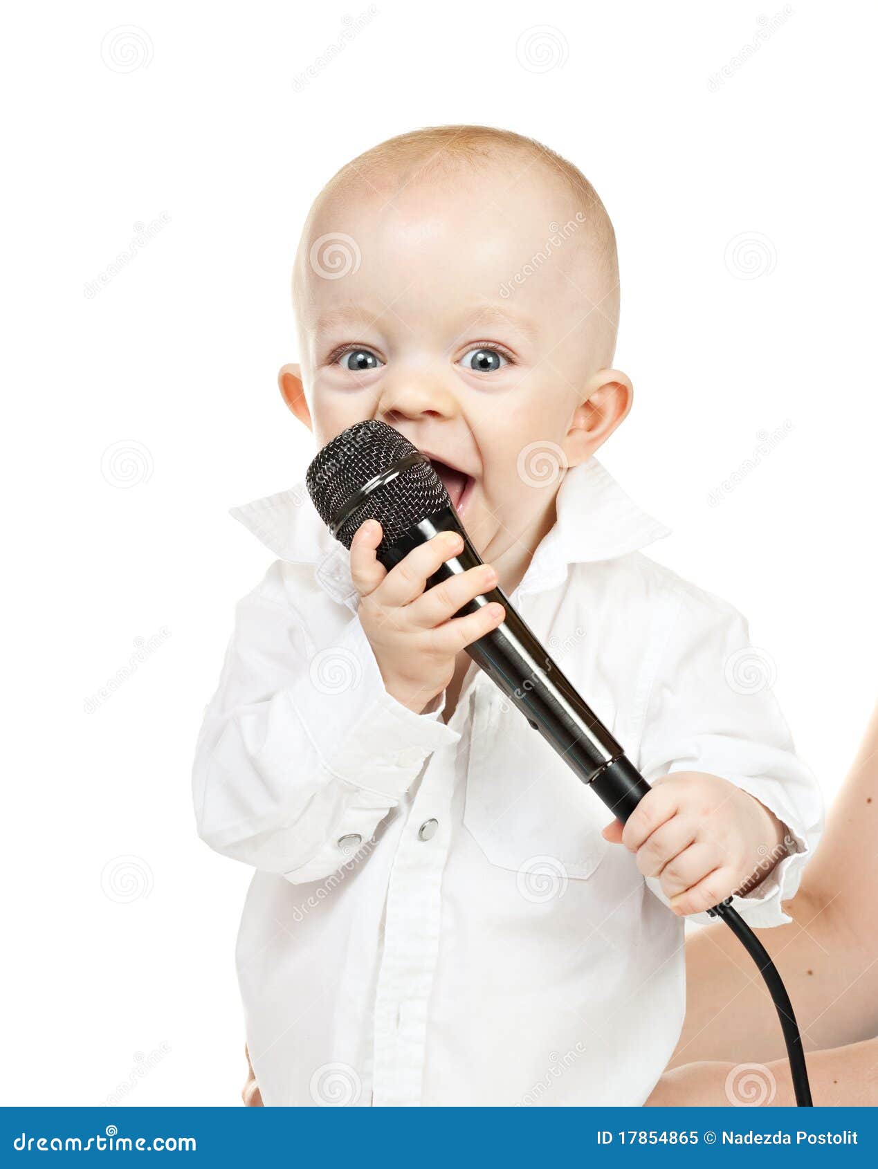 Bebé caucásico con el micrófono en un fondo blanco