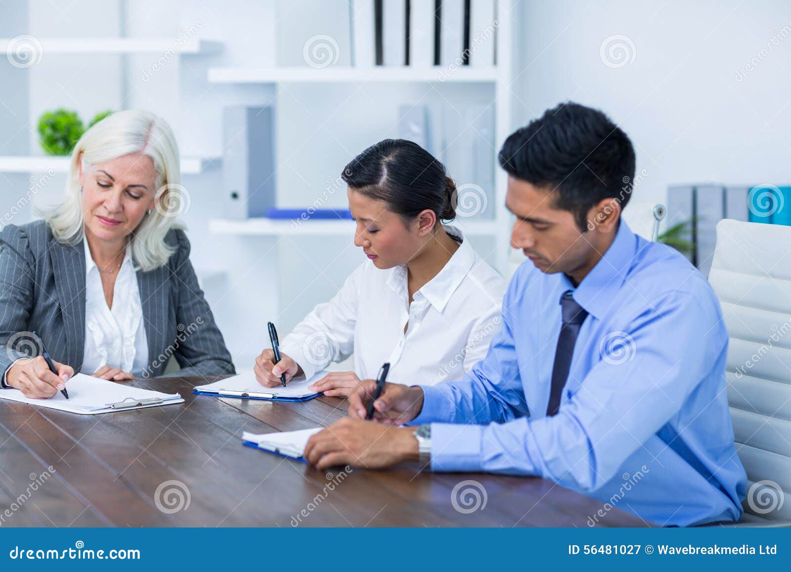 Bedrijfsmensen die op klemborden schrijven. Bedrijfsmensen die op klemborden in bureau schrijven