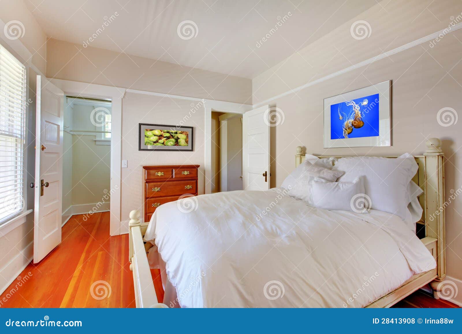 Bedroom with White Bed and Cherry Hardwood Floor. Stock Photo Image