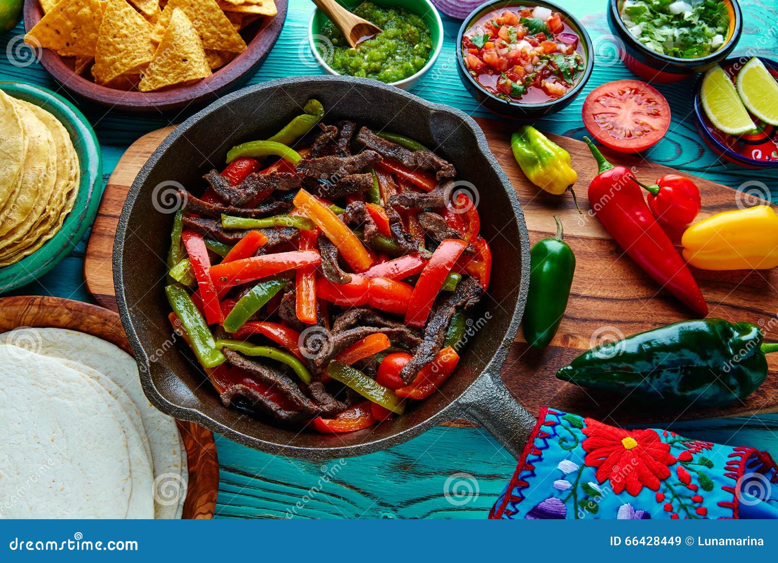 beef fajitas in a pan sauces chili and sides mexican