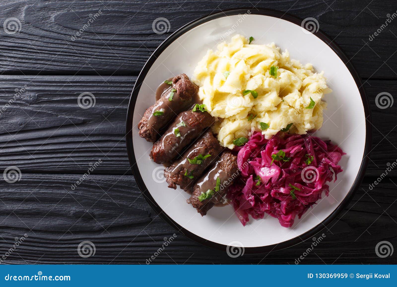 beef rouladen with gravy on a plate served with mashed potatoes