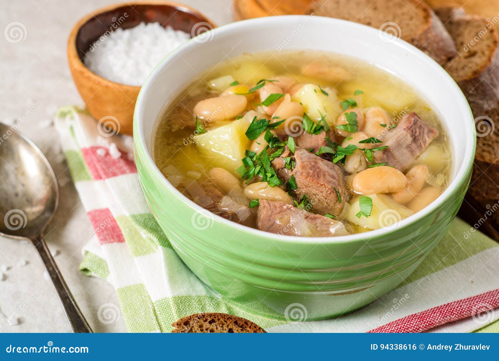 Beef Soup with Potatoes, Beans and Leeks in Ceramic Bowl on Stone