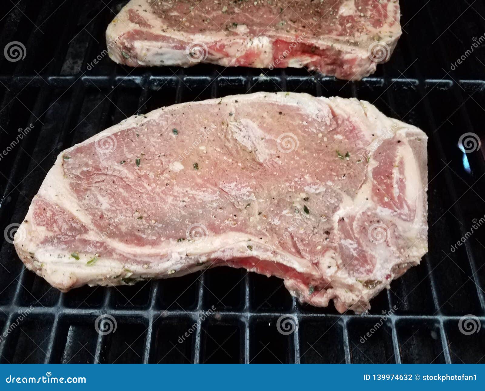 Beef Steaks with Seasoning Cooking on Barbecue Grill Stock Photo