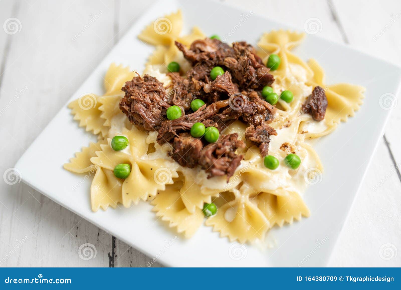 Beef Tips Over Bow Tie Pasta and Alfredo Sauce Stock Image - Image of