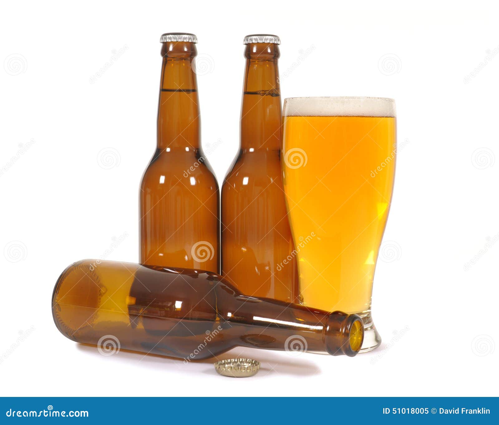 Glass of Cold Beer with Several Brown Lager Pils Bottles Isolated on