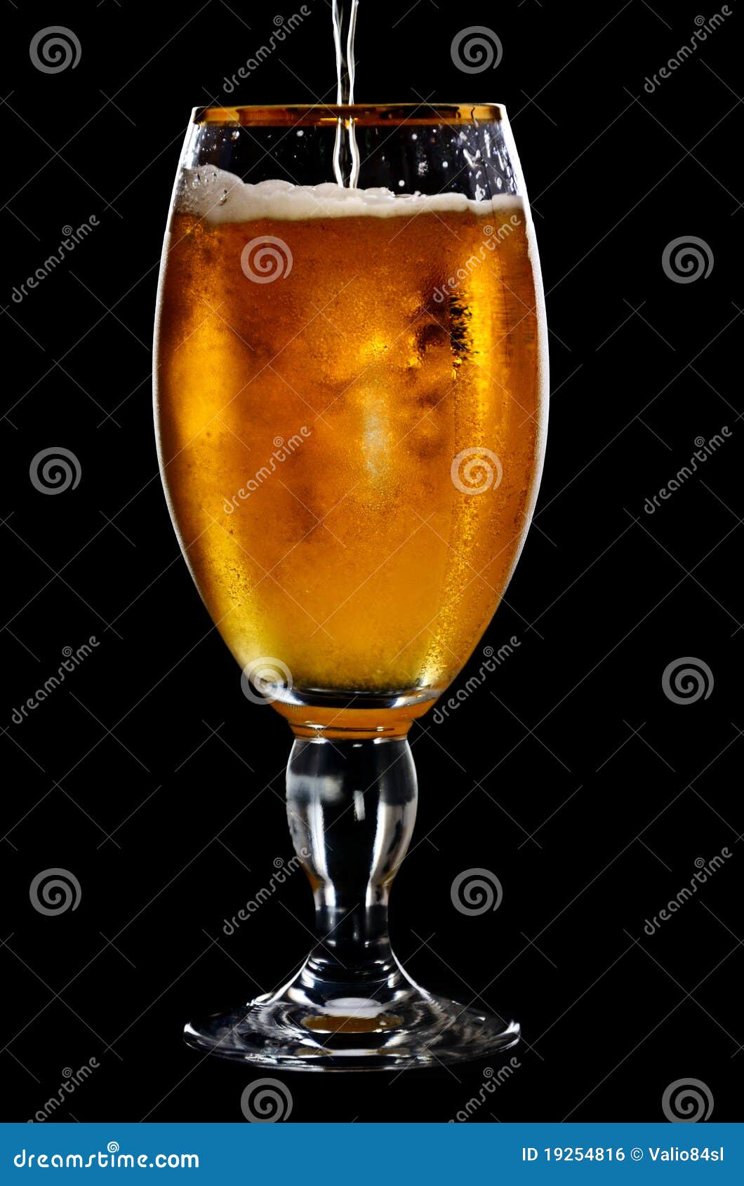 Beer into glass on a black stock photo. Image of bright 19254816