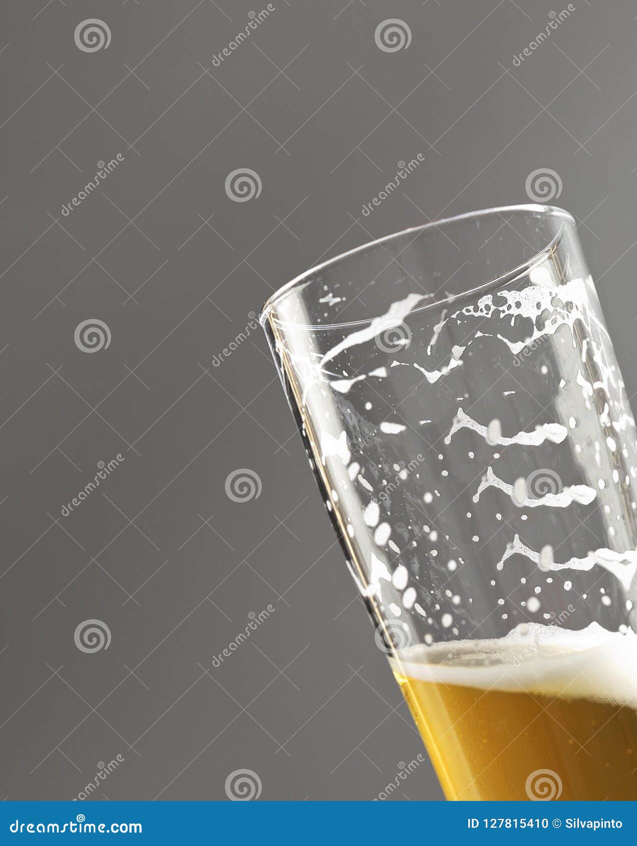 Beer Glass with Foam Marks Isolated on Gray Background. Stock Photo