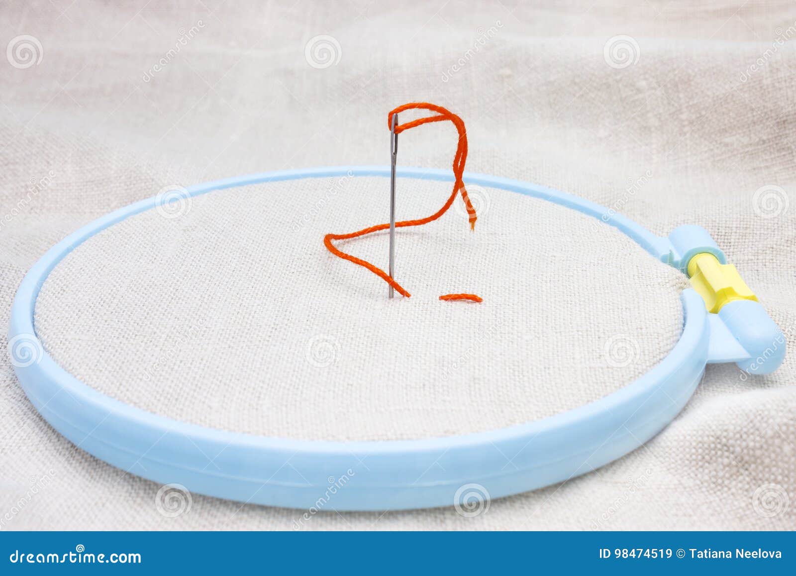 The Beginning of Needlework on an Embroidery Hoop. Needle and Orange