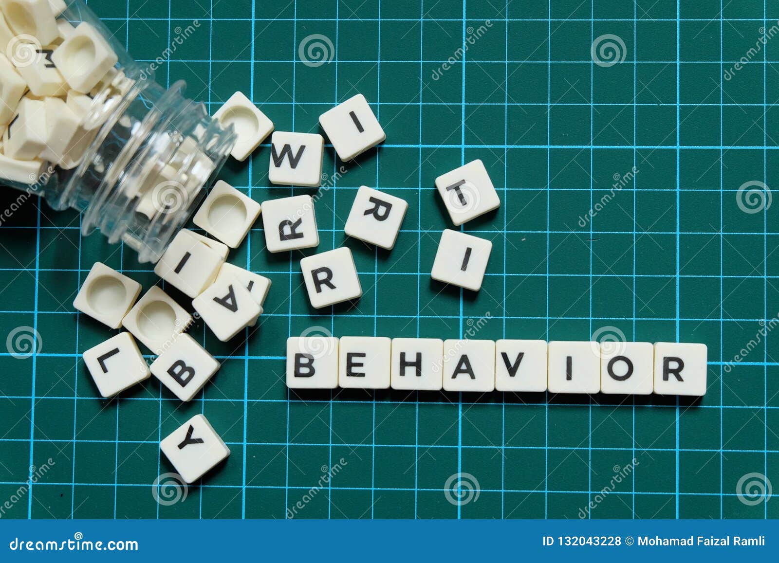 behavior word made of square letter word on green square mat background.