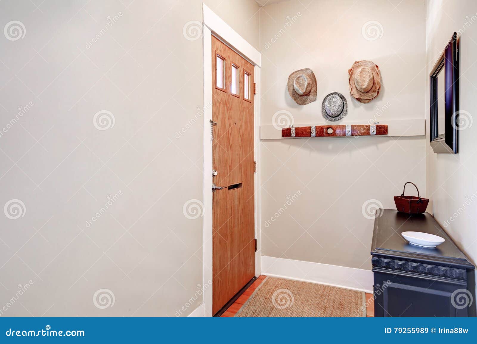 Beige Entryway With Cabinet Mirror Hats Hanging On The Wall