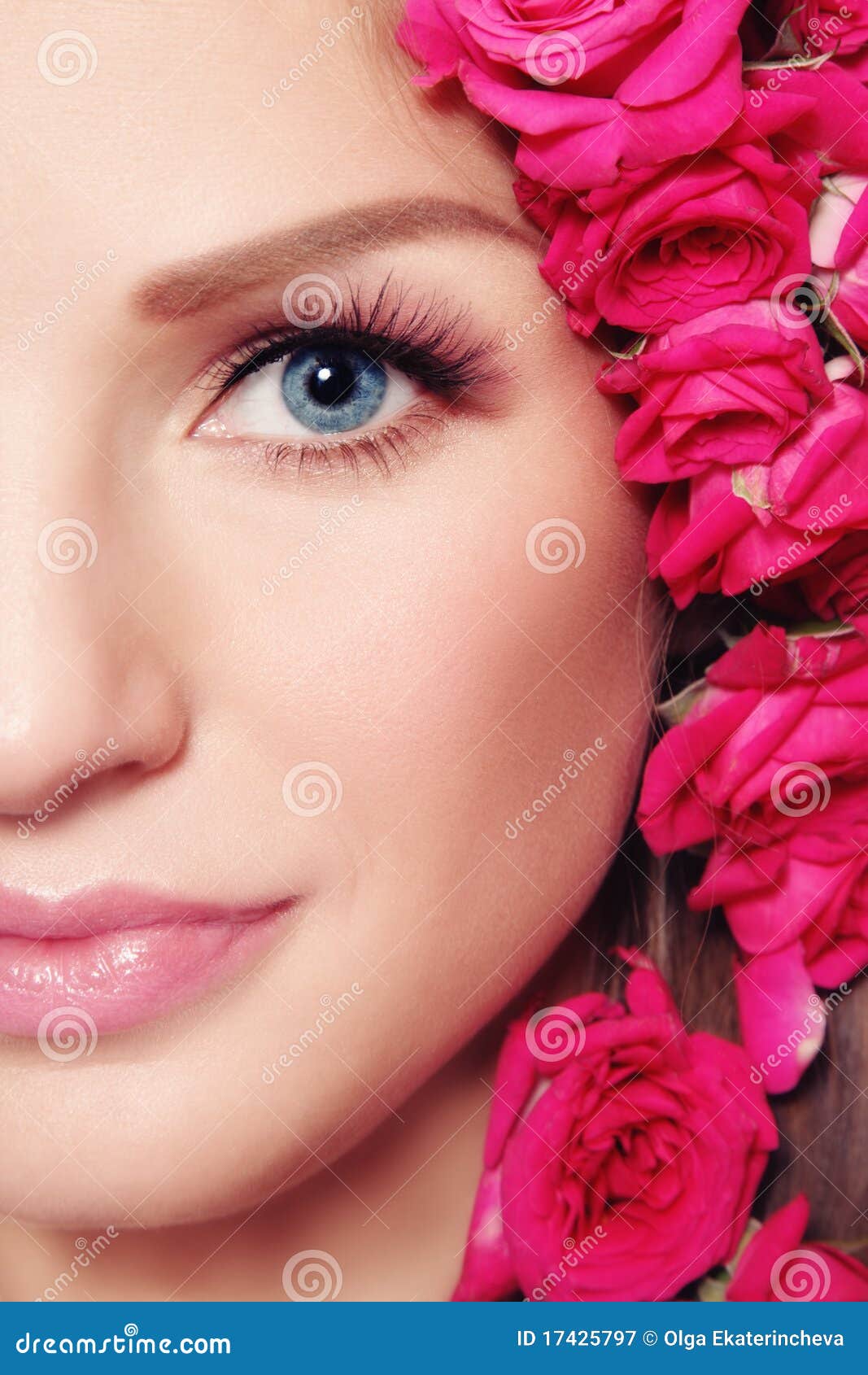 Beleza com rosas. O Close-up disparou da face bonita nova da mulher com as rosas cor-de-rosa no cabelo