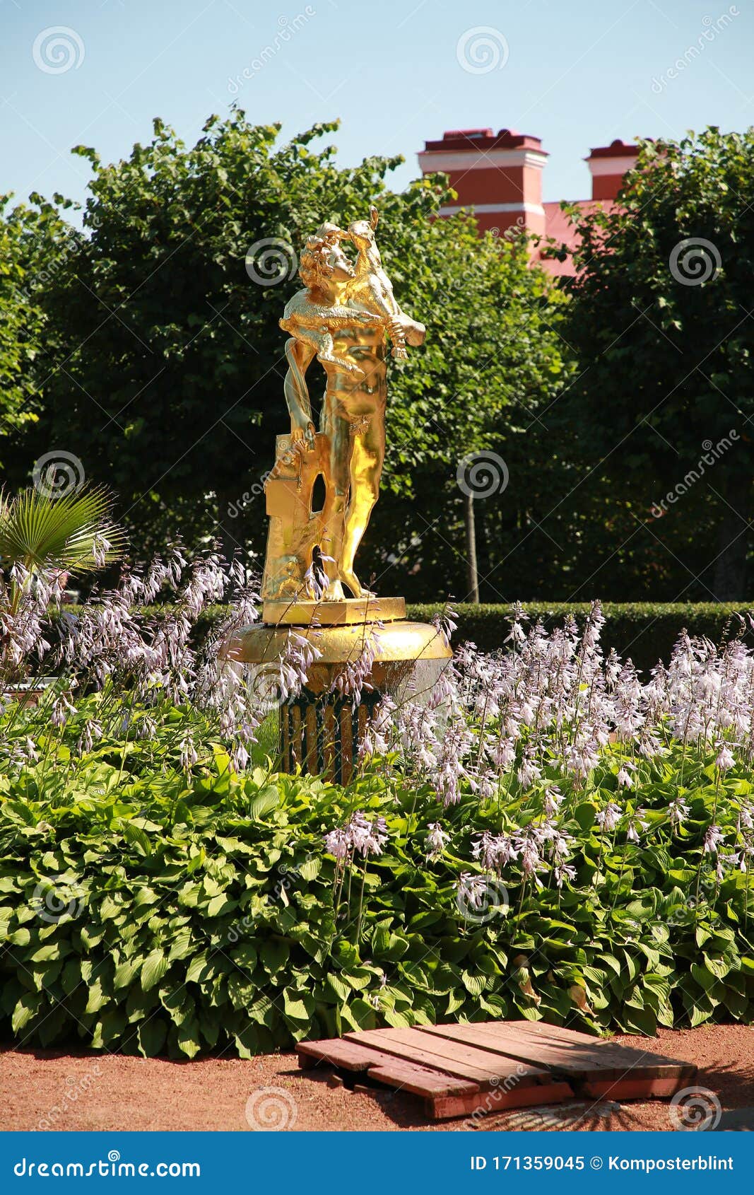 Bell Fountain With A Gilded Figure Among The Flowers In The Garden