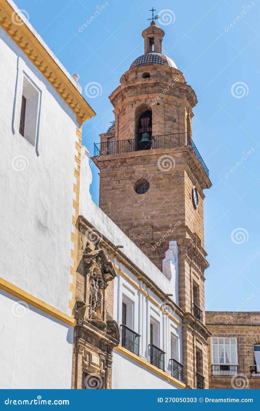 bell tower and perspective of santo domingo convent with pediment and religious statue above the entrance door, cÃ¡diz spain