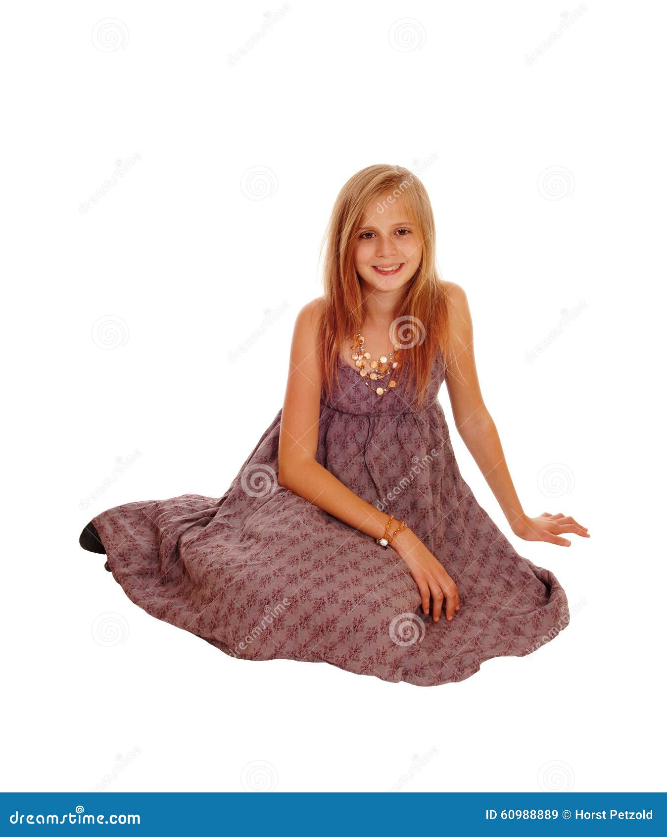 Bella bambina che si siede sul pavimento. Una bambina splendida in un sorridere di seduta del vestito da Borgogna sul pavimento, isolato per fondo bianco