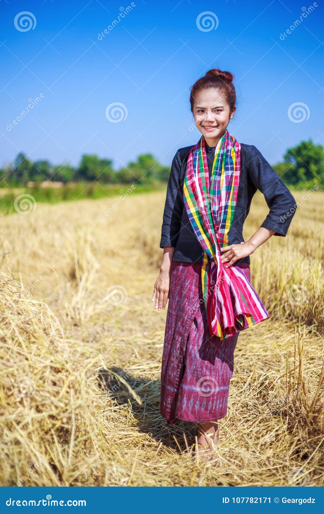 Bella donna dell'agricoltore con la paglia nel campo, Tailandia