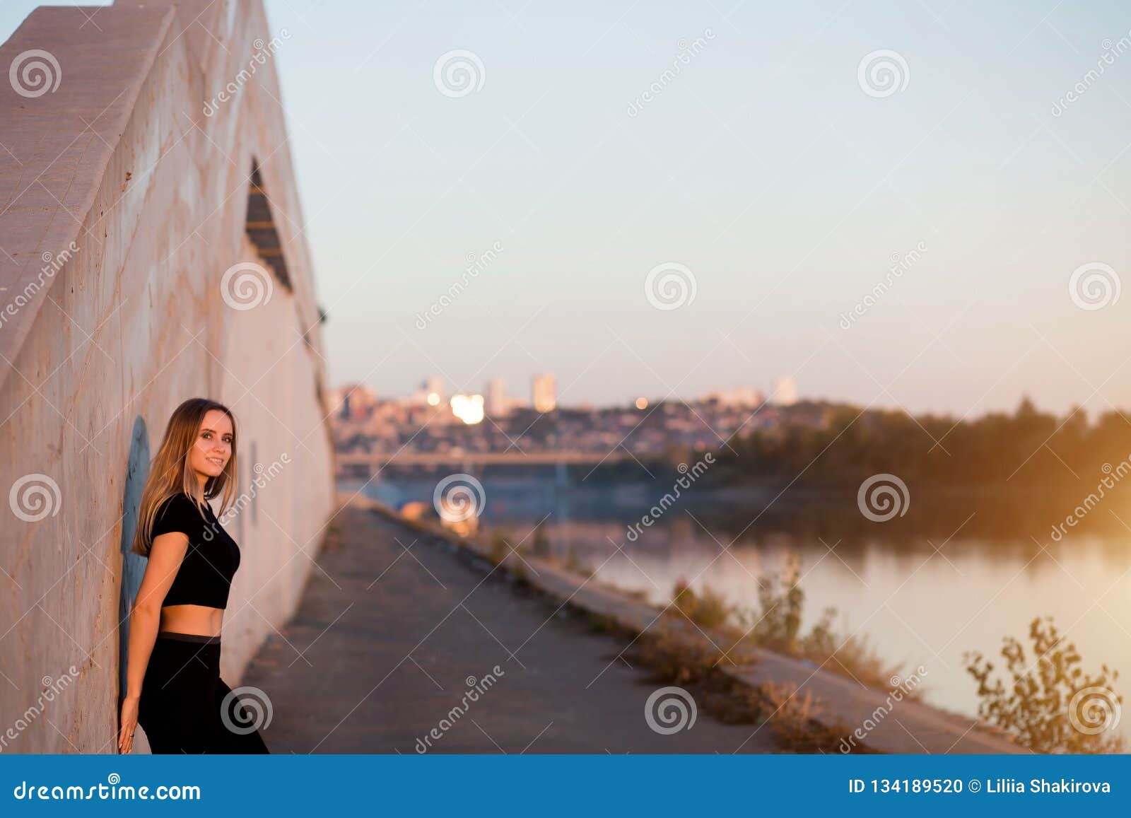 Bella donna sorridente di forma fisica sul fondo della città con copyspace. Bella donna sorridente di forma fisica sul fondo della città con lo spazio della copia