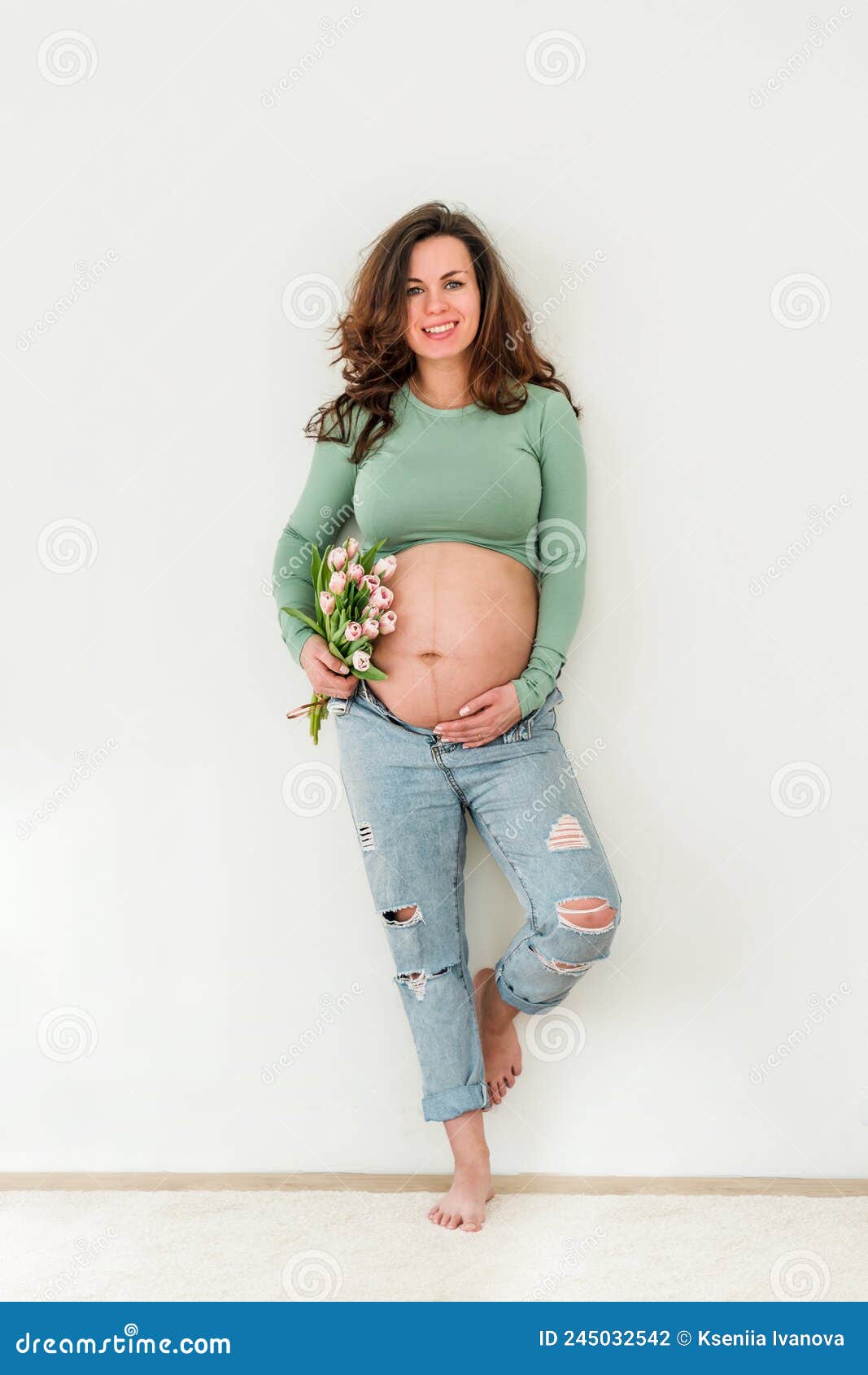 Bella Joven Mujer De Brunette Embarazada Vestida Con Ropa Moderna En  Habitación Blanca. El Concepto De Maternidad Y Embarazo Foto de archivo -  Imagen de expectativa, cuidado: 245032542