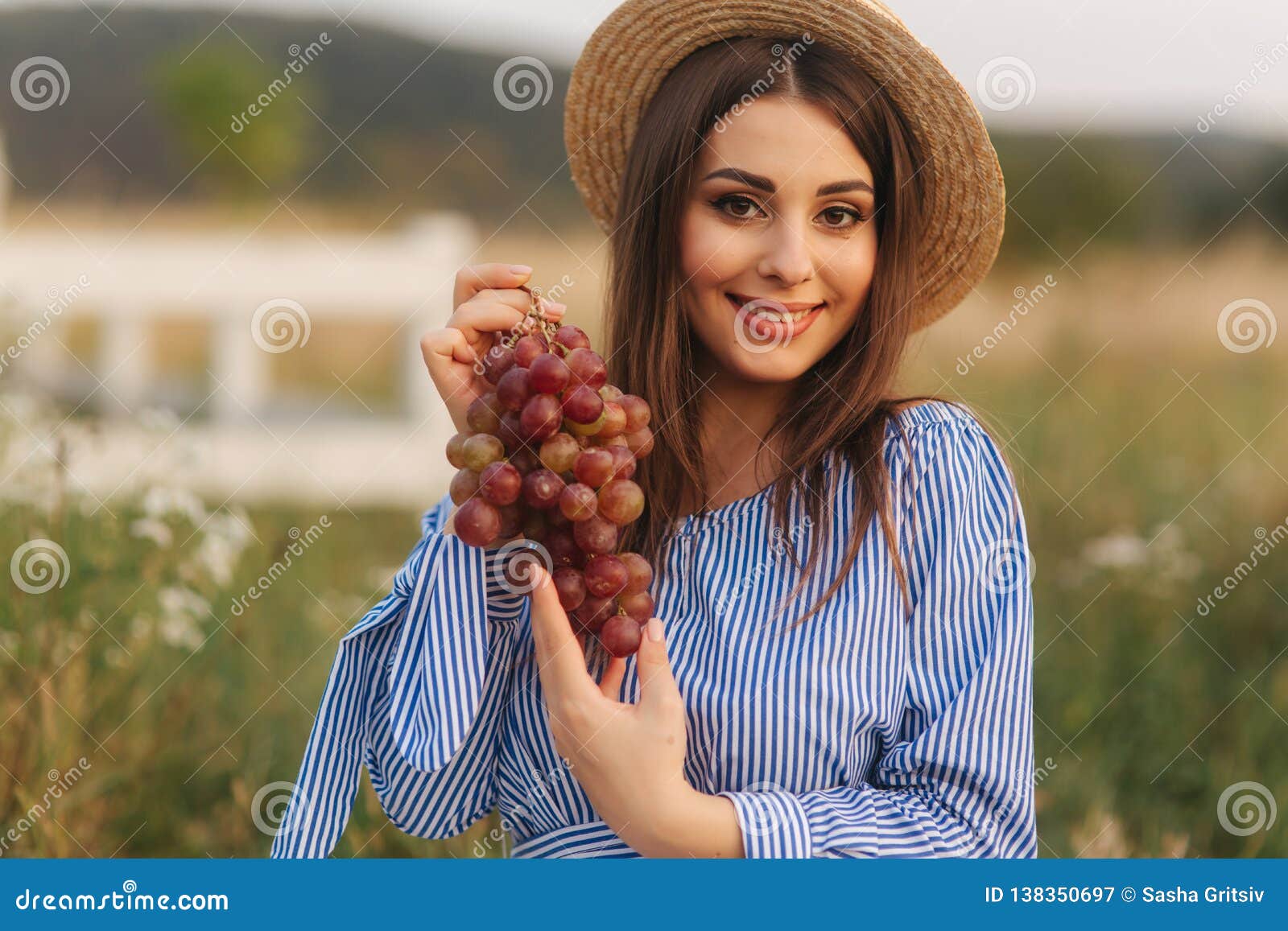 Bella manifestazione della donna incinta e mangiare l'uva rossa Alimento sano Frutta fresca Sorriso felice della donna