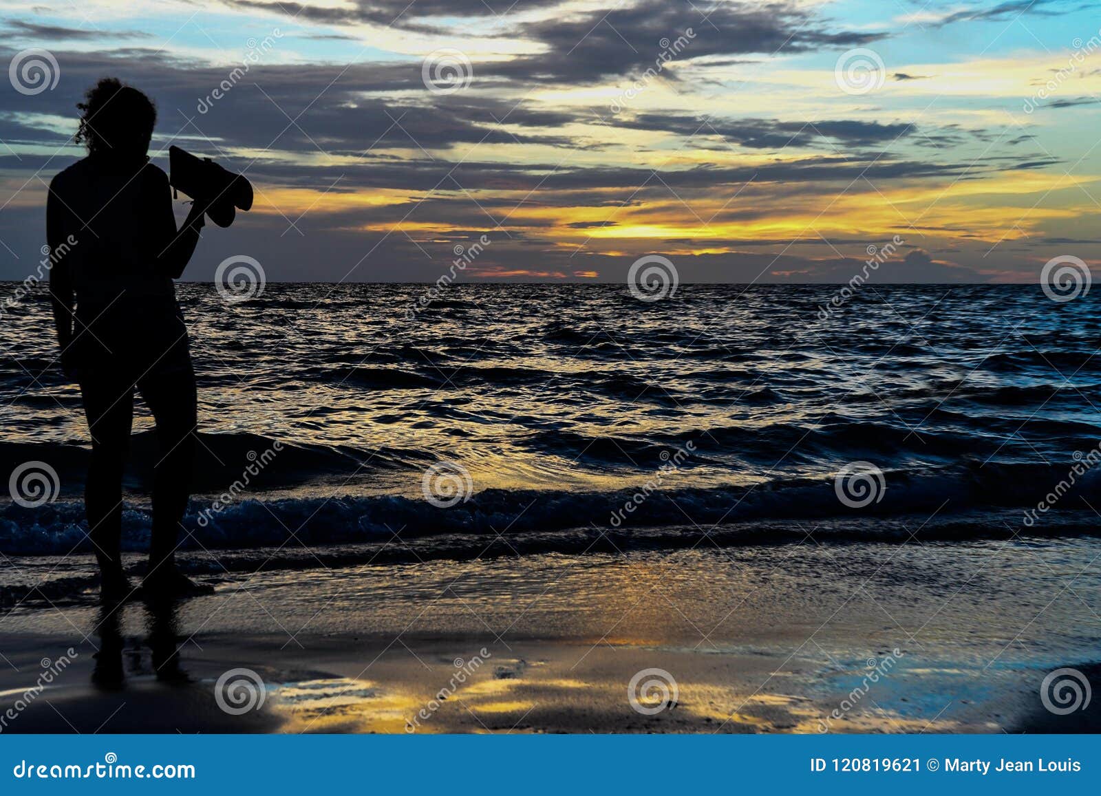 Bella signora al tramonto. La siluetta di bella giovane donna guarda il sole mettere alla spiaggia