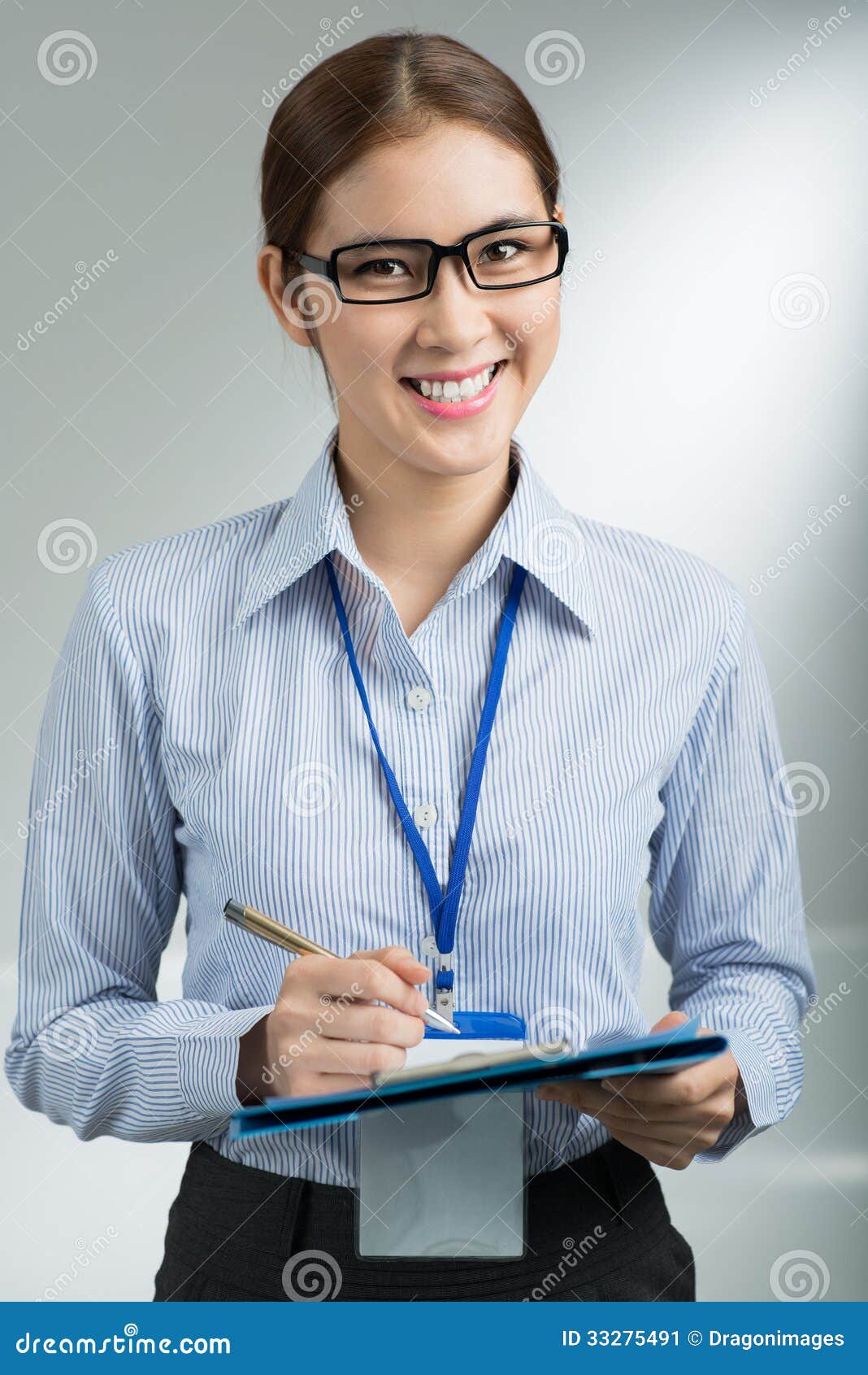 Belle femme d'affaires. Portrait vertical d'une jeune femme d'affaires attirante souriant et regardant l'appareil-photo au-dessus d'un fond gris