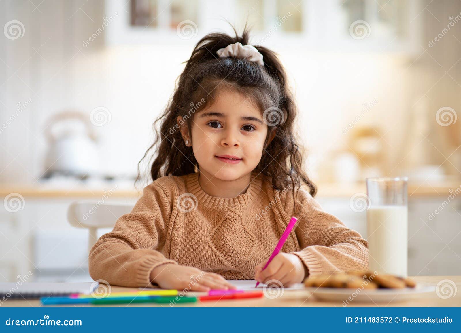 Belle Petite Fille Arabe Assis à La Table Dans La Cuisine Et Le Dessin  Photo stock - Image du lait, chéri: 211483572
