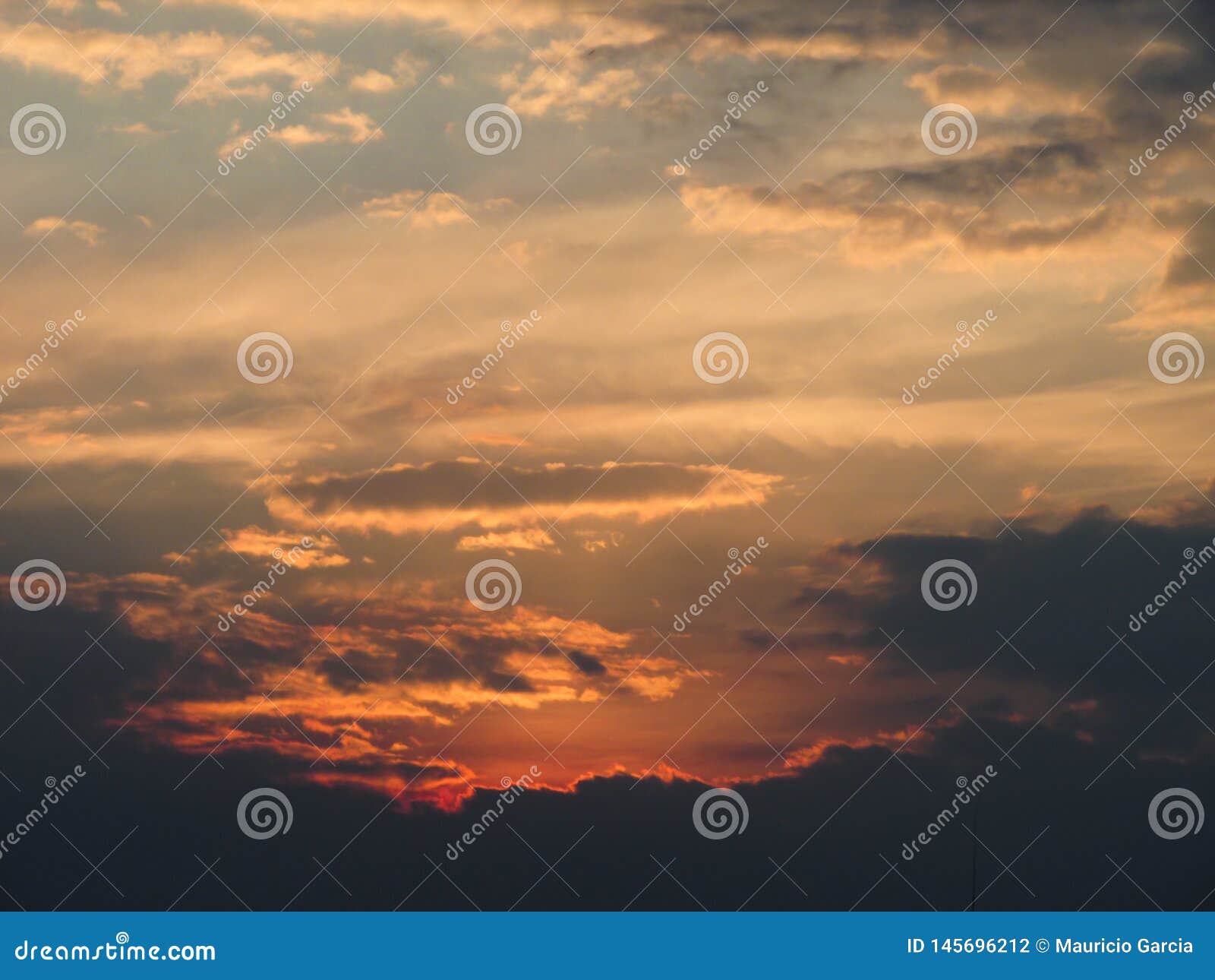 atardecer naranja en cielo lleno de nubes