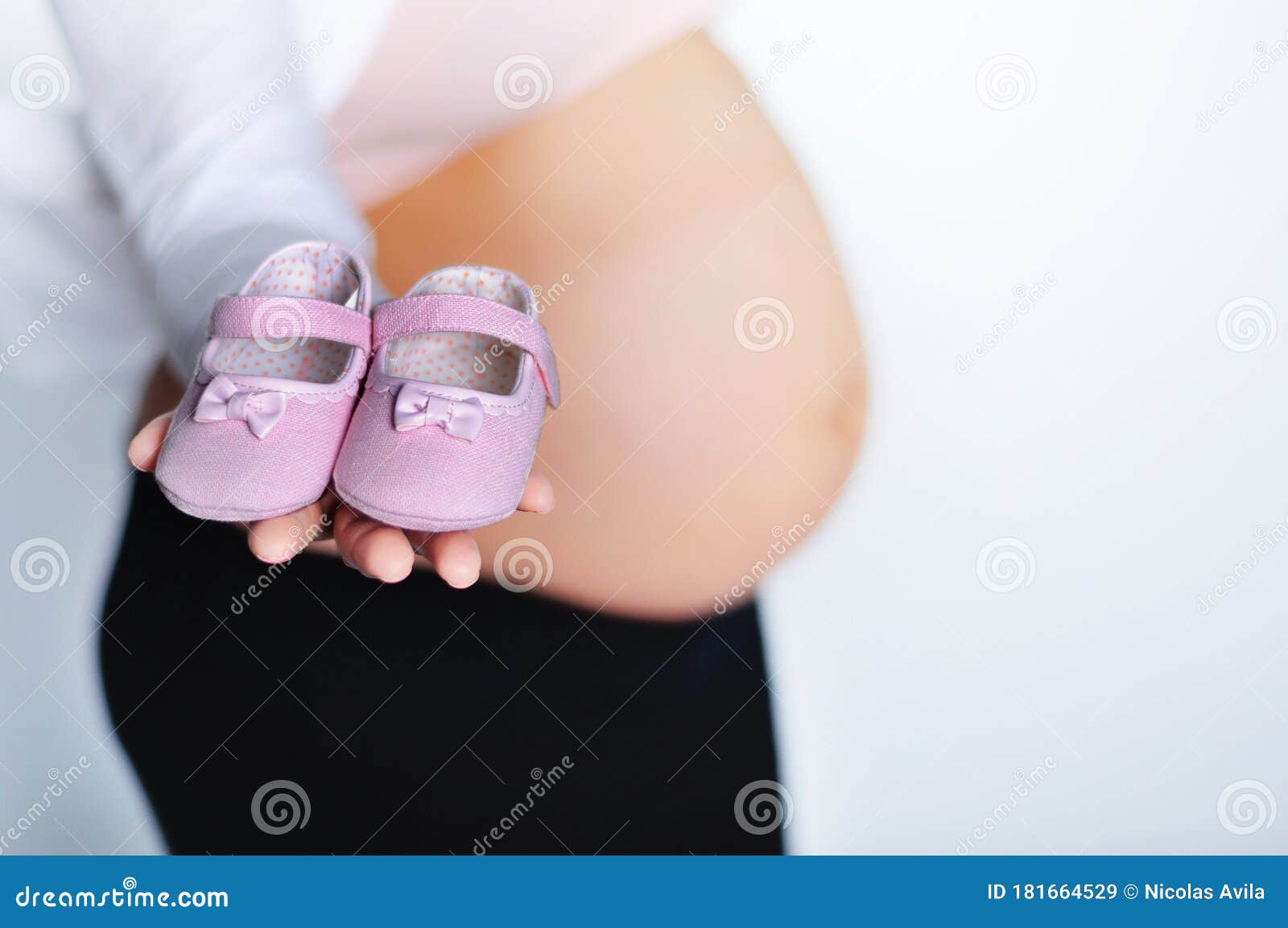 pregnant woman with little shoes in her hand