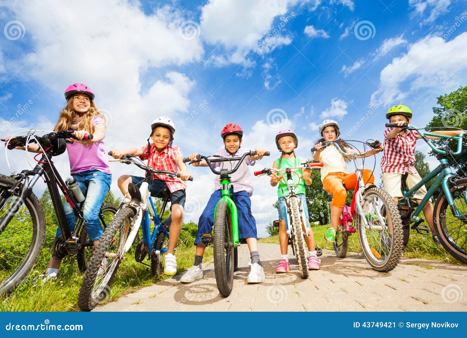 below angle view of kids in helmets with bikes