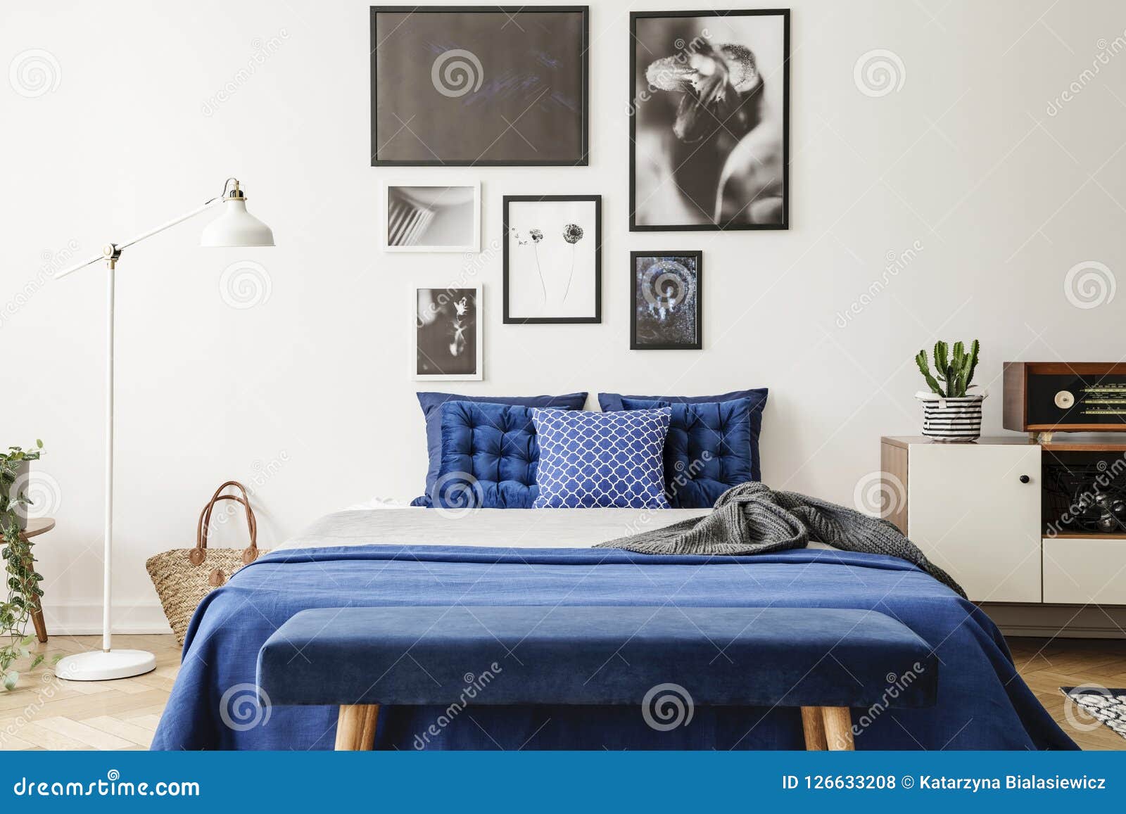 Bench in Front of Bed with Navy Blue Pillows between Lamp and Cabinet in  Bedroom Interior. Real Photo Stock Photo - Image of wooden, room: 126633208