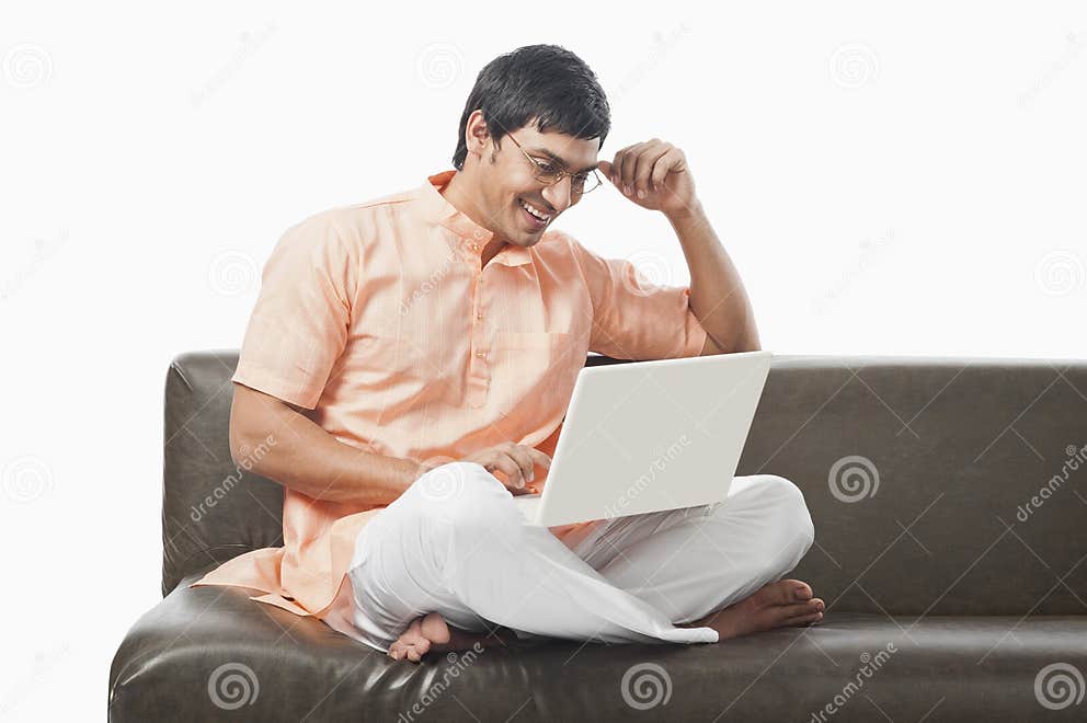 Bengali Man Using a Laptop on the Couch Stock Image Image of looking