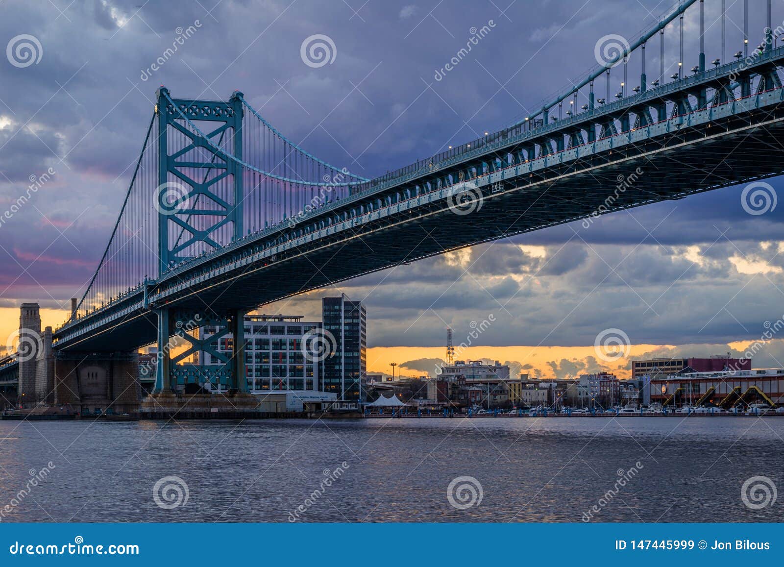 Benjamin Franklin Bridge en en de Rivier van Delaware bij zonsondergang, die van Camden, New Jersey wordt gezien