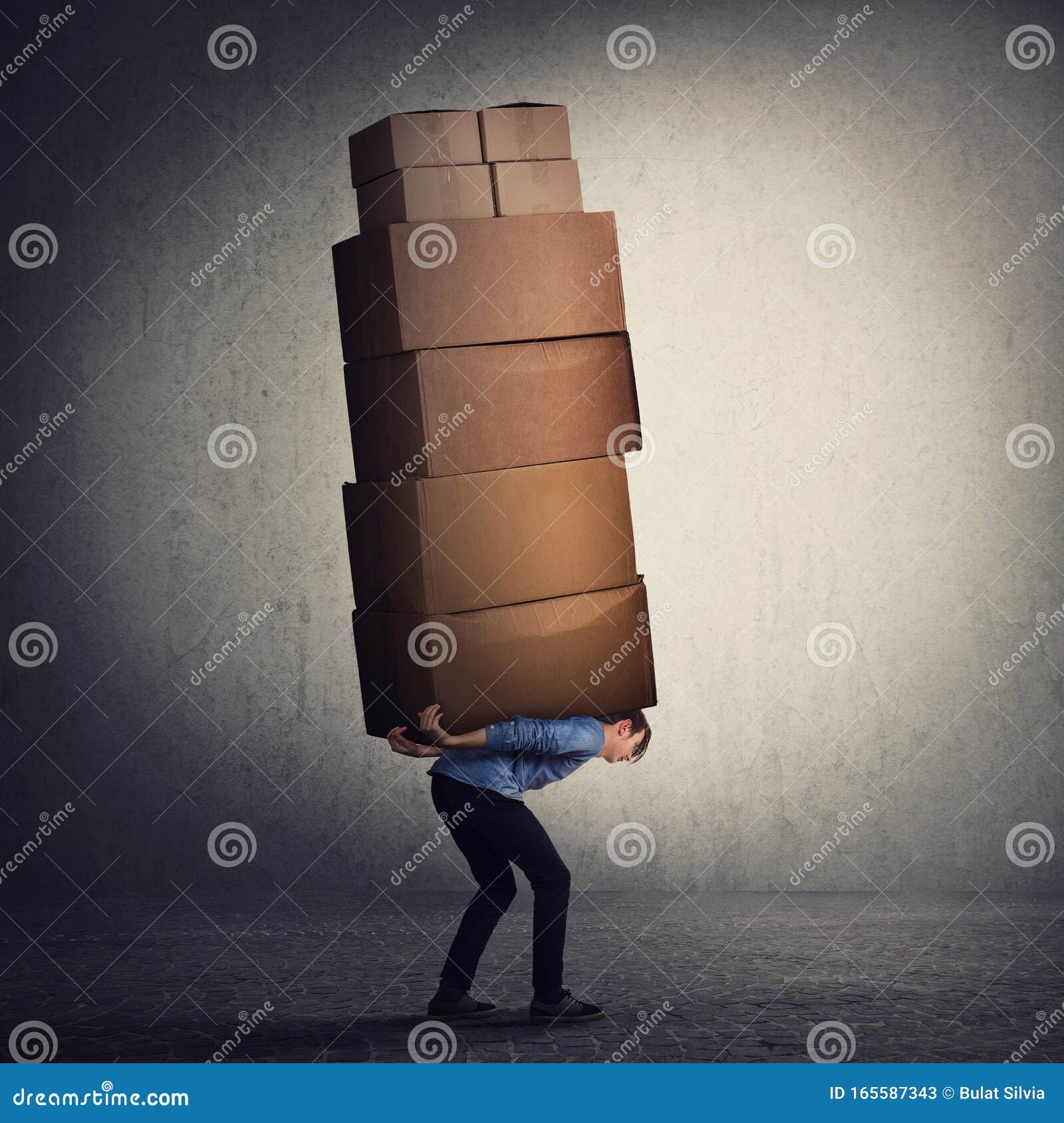 bent down guy carrying a lot of big heavy boxes on his back. overloaded of daily tasks, and difficult burden. packing stuff and