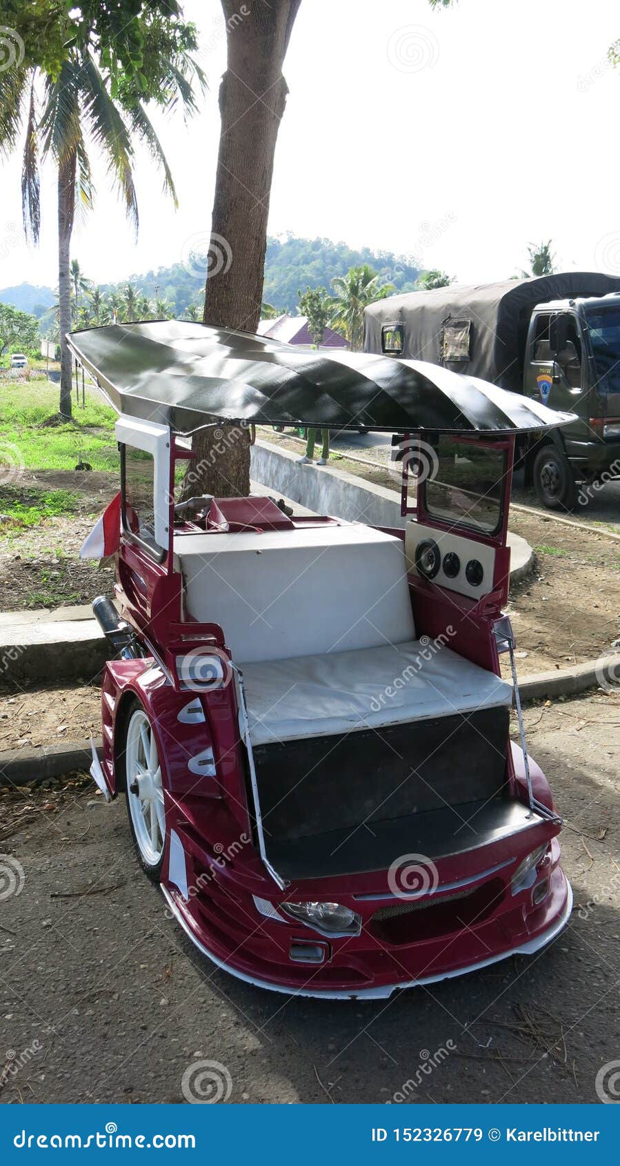 bentor modified scooter that is used to transport people as a taxi.widespread on sulawesi in the city of kotamobag. red motorbike.