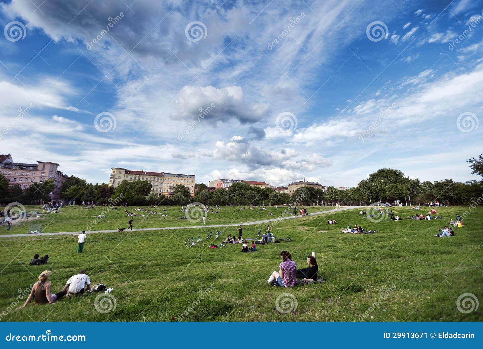 Tiempo libre en el parque Berlín Alemania de Gorlitzer. Berlín, Alemania - 8 de junio de 2012: Los grupos de adultos y de adolescentes jovenes dispersaron en la hierba en el parque de Gorlitzer, situado en Kreuzberg, Berlín del este, Alemania; en un día de primavera soleado precioso.