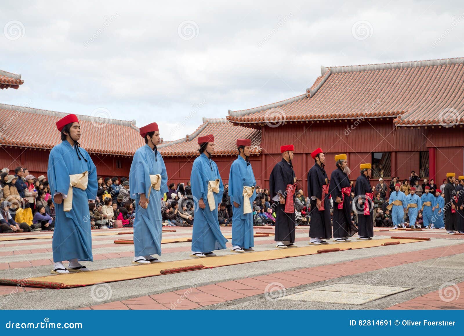 Beröm för nytt år på den Shuri slotten i Okinawa, Japan. Okinawa Japan - Januari 02, 2015: Utklätt folk som utför en show för åskådare på den traditionella berömmen för nytt år på den Shuri-jo slotten